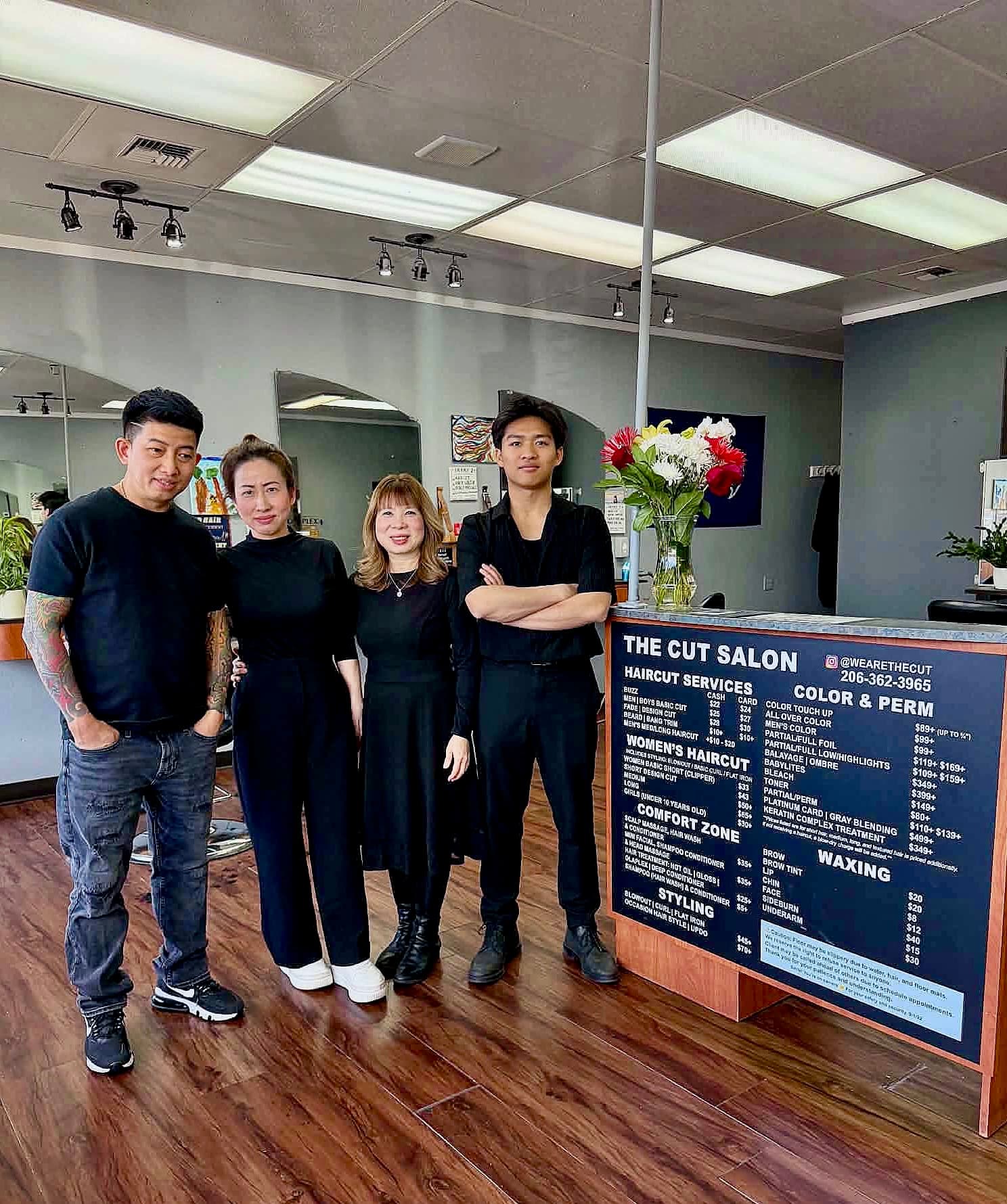 The four-person team at The Cut salon in Shoreline, standing beside the reception counter